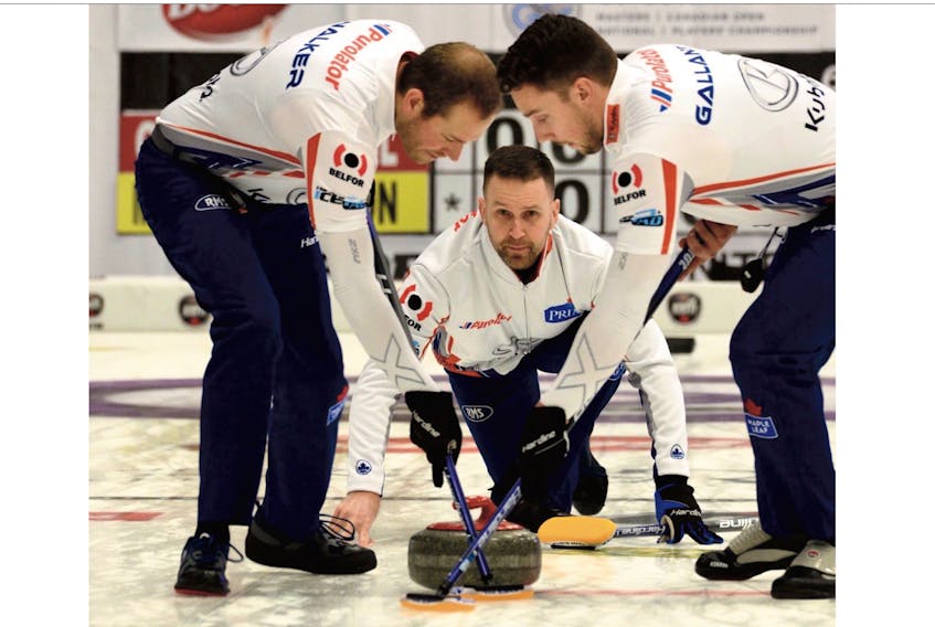 Skip Brad Gushue watches as lead Geoff Walker (left) and second Brett Gallant (right) begin to sweep his rock during their game at the Boost National at the Conception Bay South Arena Tuesday night.  — Keith Gosse/The Telegram