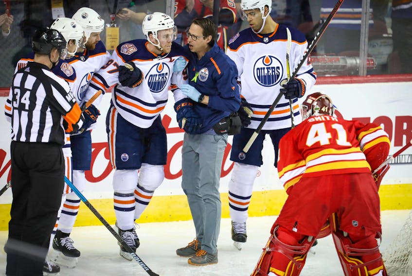 Edmonton Oilers captain Connor McDavid is helped off the ice after colliding with the goalpost against the Calgary Flames at the Scotiabank Saddledome on April 6, 2019.