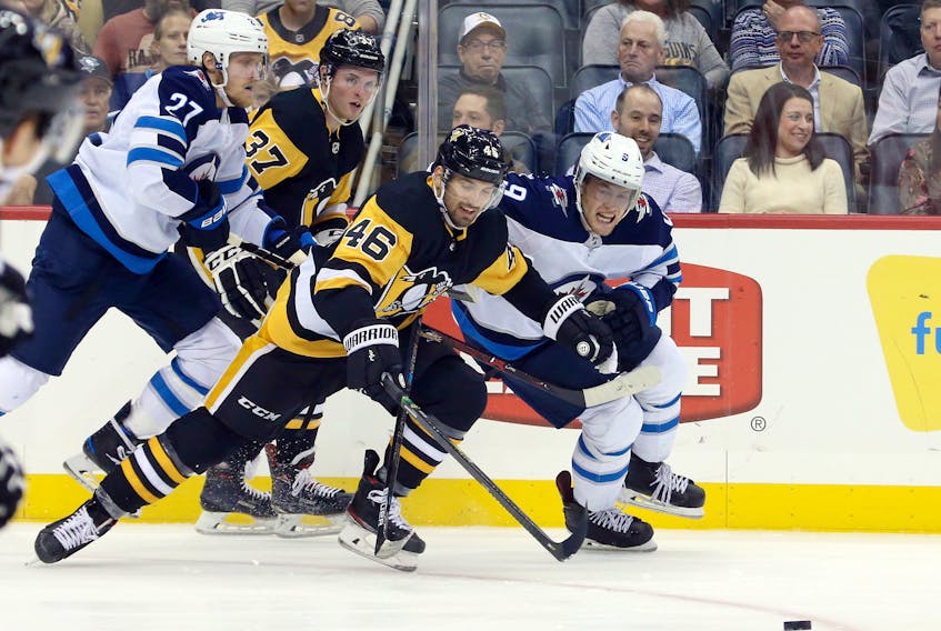 Pittsburgh Penguins center Zach Aston-Reese (46) chases against Winnipeg Jets center Andrew Copp (9) during the third period at PPG PAINTS Arena on Tuesday. Winnipeg won 4-1.Charles LeClaire-USA TODAY Sports 