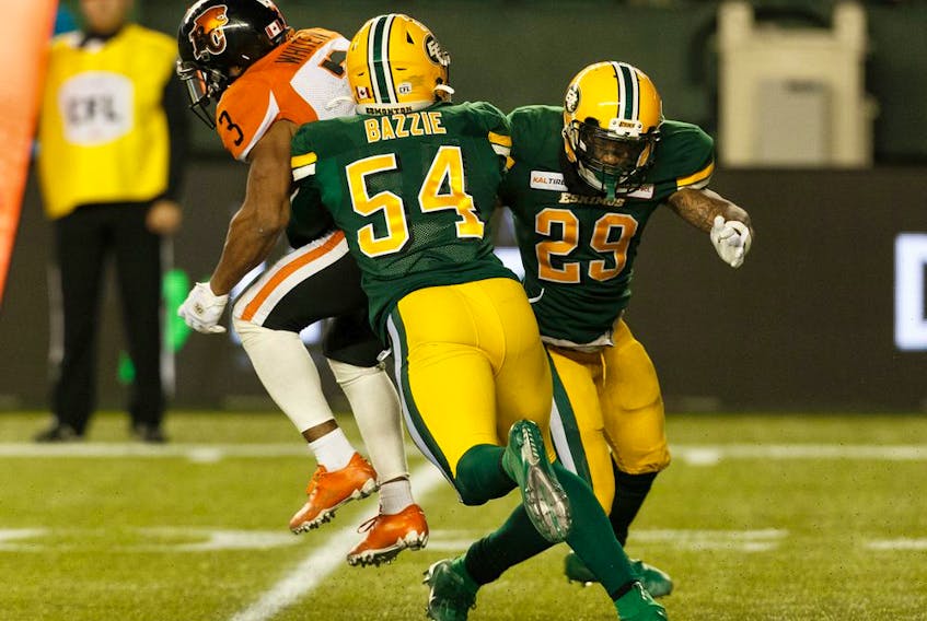 Edmonton Eskimos' Alex Bazzie (54) and Brian Walker (29) tackle BC Lions' John White IV (3) in the backfield during second half CFL action at Commonwealth Stadium in Edmonton, on Saturday, Oct. 12, 2019. 