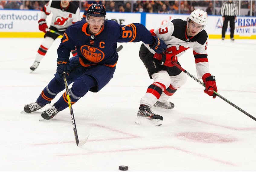 Edmonton Oilers' Connor McDavid (97) battles New Jersey Devils' Nico Hischier (13) at Rogers Place in Edmonton, on Friday, Nov. 8, 2019. 