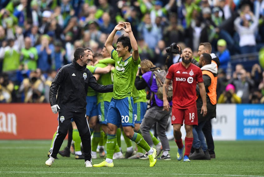 Seattle Sounders midfielder Kim Kee-Hee (20) celebrates after the MLS Cup against Toronto FC midfielder Nick DeLeon (18) at CenturyLink Field. Steven Bisig-USA TODAY Sports 