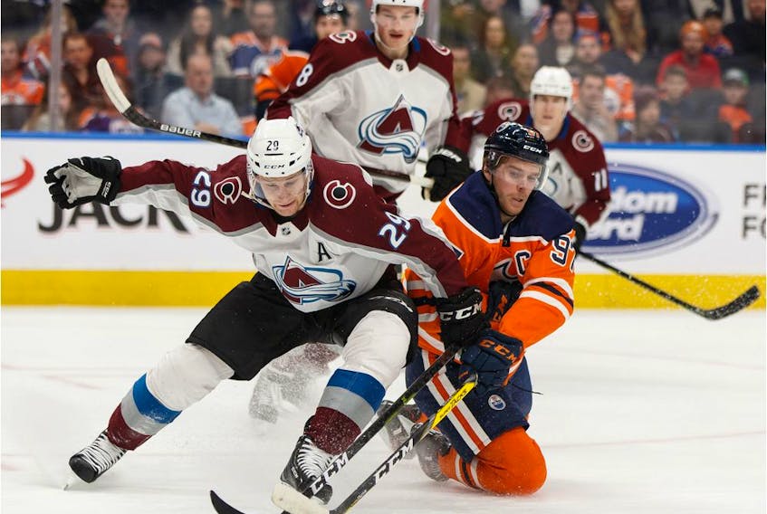 Edmonton Oilers' Connor McDavid (97) battles Colorado Avalanche's Nathan MacKinnon (29) during a NHL hockey game at Rogers Place in Edmonton, on Thursday, Nov. 14, 2019.