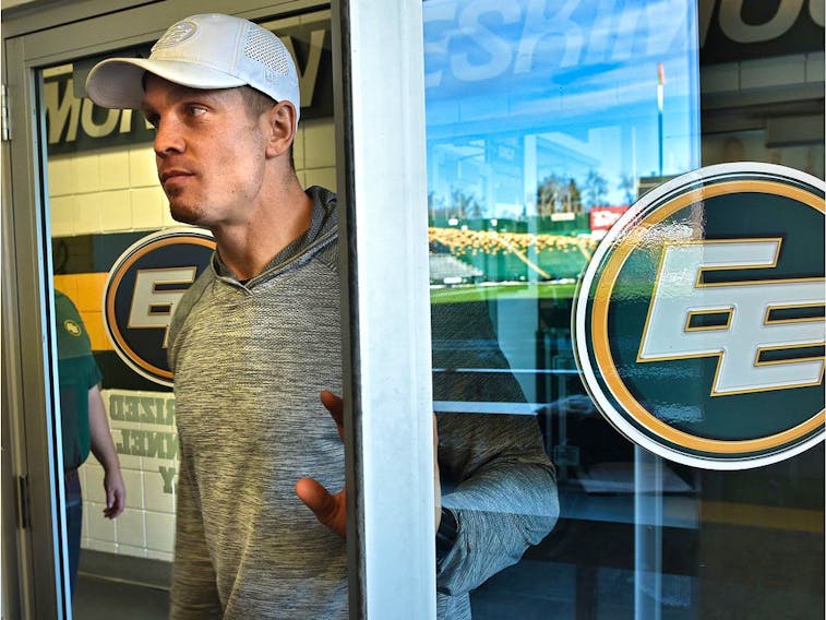 Eskimos quarterback Trevor Harris opens a door with the Commonwealth Stadium field reflected off the glass, on his way to speak to the media after their season ended in the Eastern Finals Sunday losing to Hamilton, in Edmonton, November 18, 2019.  