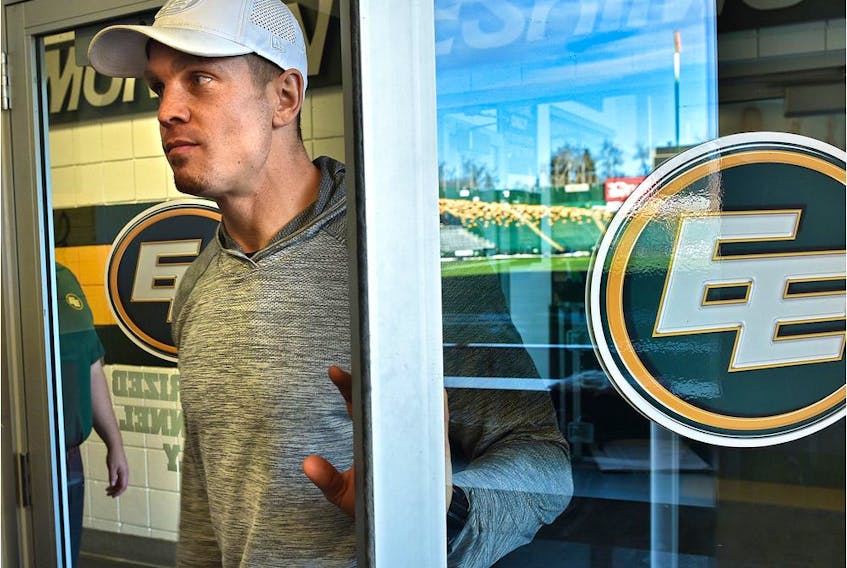 Eskimos quarterback Trevor Harris opens a door with the Commonwealth Stadium field reflected off the glass, on his way to speak to the media after their season ended in the Eastern Finals Sunday losing to Hamilton, in Edmonton, November 18, 2019.  