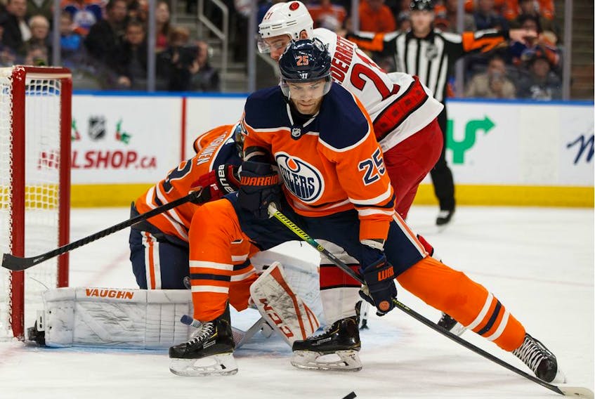 Edmonton Oilers' Darnell Nurse (25) battles Carolina Hurricanes' Nino Niederreiter (21) during the second period of a NHL hockey game at Rogers Place in Edmonton, on Tuesday, Dec. 10, 2019. 