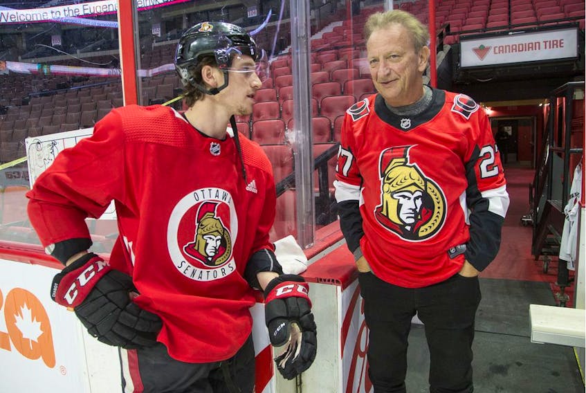 Senators owner Eugene Melnyk chats with defenceman Thomas Chabot, left, during the annual Eugene Melnyk Skate for Kids at Canadian Tire Centre on Dec. 20.