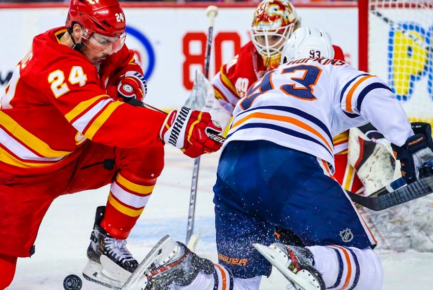 Calgary Flames defenceman Travis Hamonic (24) and Edmonton Oilers center Ryan Nugent-Hopkins (93) battle for the puck during the second period at Scotiabank Saddledome. 