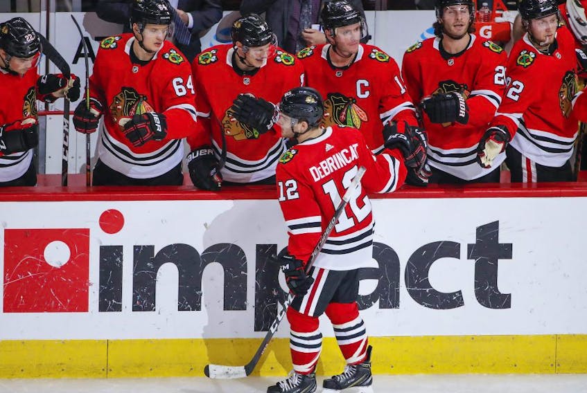 Chicago Blackhawks left wing Alex DeBrincat (12) celebrates with teammates after scoring against the Edmonton Oilers during the second period at United Center. 