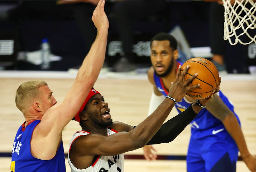 Terence Davis of the Toronto Raptors drives the ball against Mason Plumlee of the Denver Nuggets during the third quarter at The Field House at ESPN Wide World Of Sports Complex.