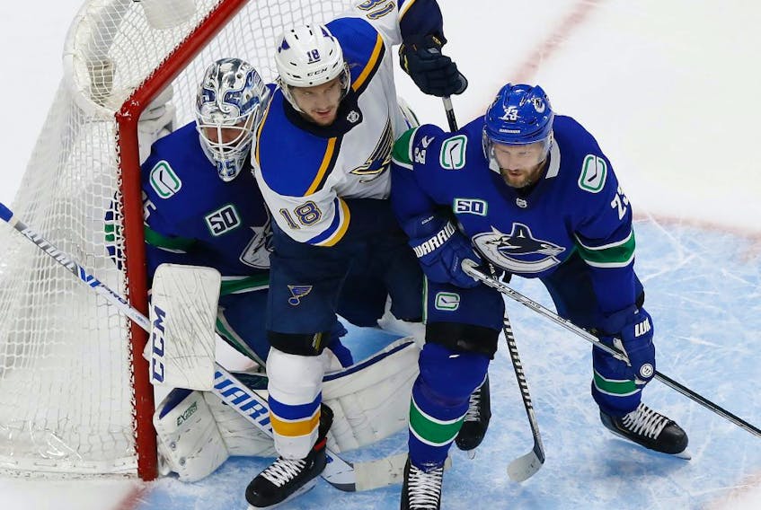 Blues center Robert Thomas (18) battles for position against Vancouver Canucks goaltender Jacob Markstrom (25) and defenseman Alexander Edler (23) during the third period in game six of the first round of the 2020 Stanley Cup Playoffs at Rogers Place on Aug. 21, 2020. 