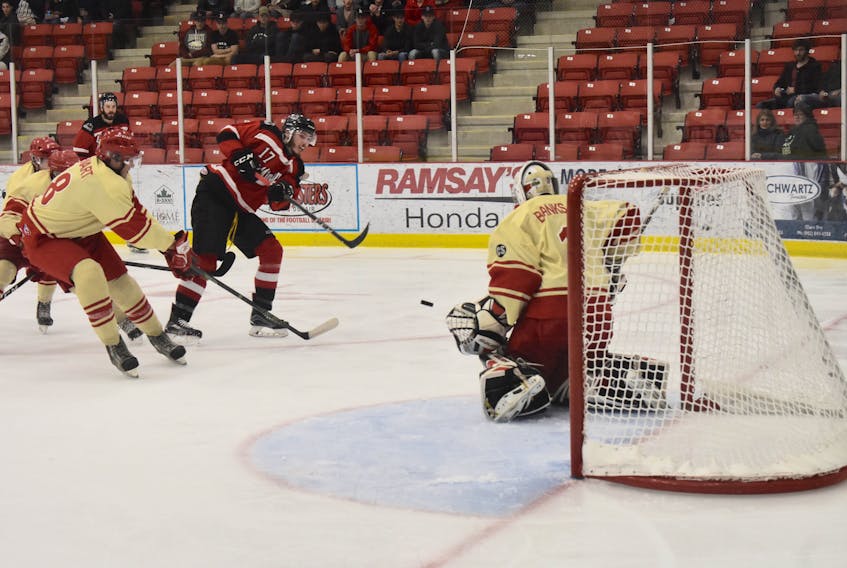 Mitchell Johnston, middle, of the Kameron Junior Miners fires a shot on Western Red Wings netminder Bronson Banks, right, during Don Johnson Memorial Cup action at the Membertou Sport and Wellness Centre on Friday. The Junior Miners will play in the tournament championship game on Sunday, after defeating the East Hants Penguins 5-2 in the semifinal on Saturday. The Cape Breton club will play the Mount Pearl Blades of Newfoundland and Labrador at 2 p.m. for gold.