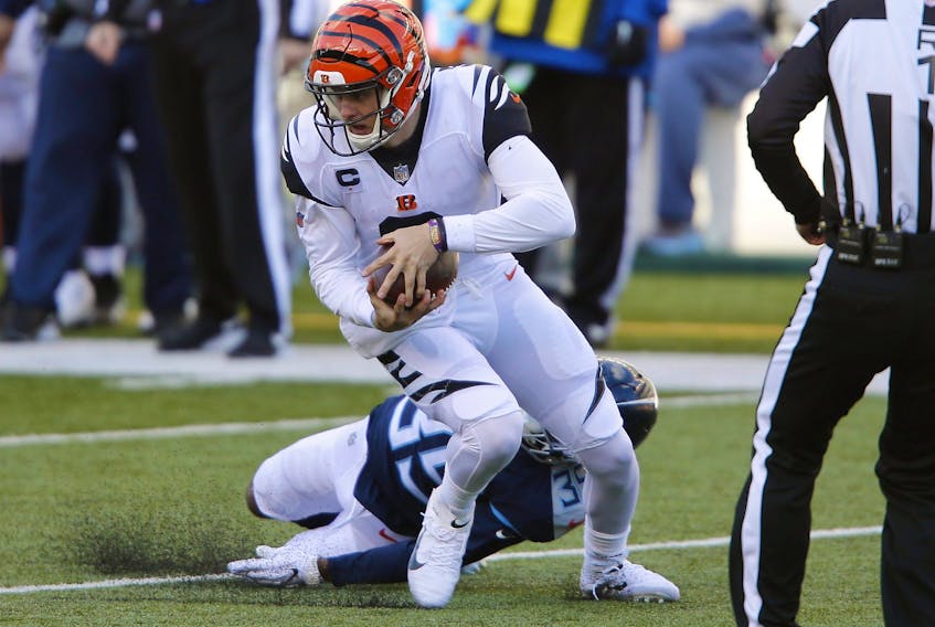 Bengals quarterback Joe Burrow breaks a tackle against Titans defensive back Chris Jackson yesterday. Burrow led the Bengals to an upset win over the Titans.