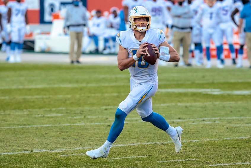 Chargers quarterback Justin Herbert rolls out to pass against the Denver Broncos.