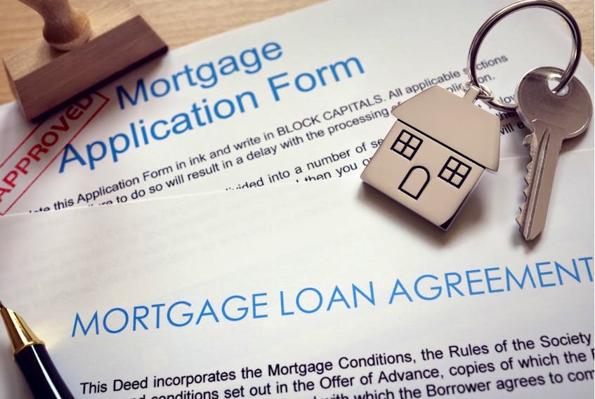 Mortgage loan agreement application with  key on house shaped keyring. Getty Images.