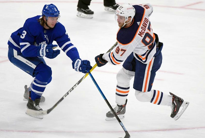 Toronto Maple Leafs defenceman Justin Holl (3) steals the puck away from Edmonton Oilers forward Connor McDavid (97) in the second period at Scotiabank Arena on Jan. 20, 2021. 