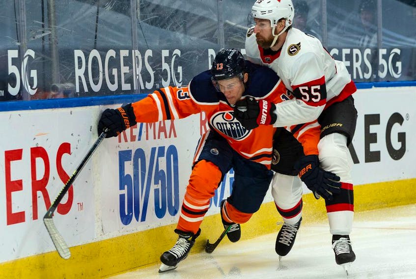 Edmonton Oilers' Jesse Puljujarvi (13) battles Ottawa Senators' Braydon Coburn (55) during first period NHL action at Rogers Place in Edmonton, on Tuesday, Feb. 2, 2021. 