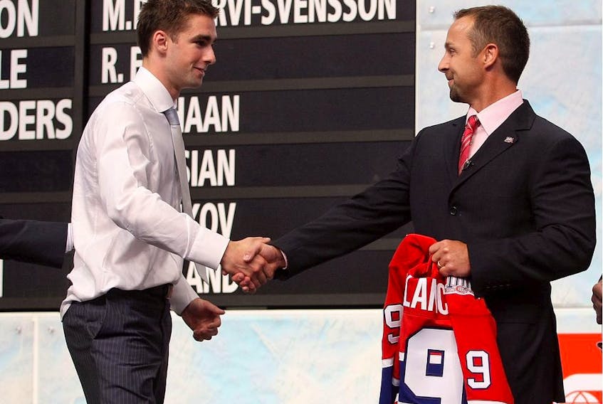 Canadiens assistant GM Trevor Timmins shakes hands with Louis Leblanc after selecting him in the first round (18th overall) of the 2009 NHL Draft at the Bell Centre in Montreal.   