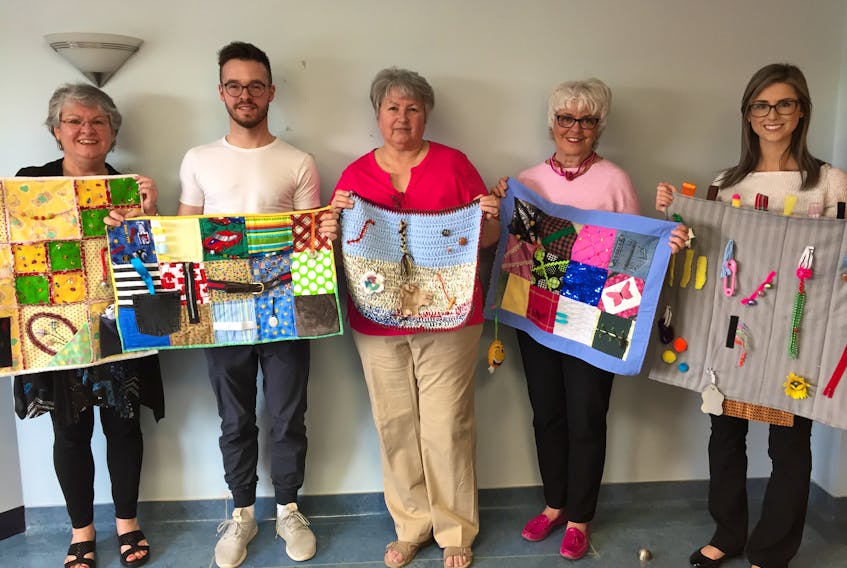 Showing off the new quilts are, from left, Priscilla Sharkey, Northern zone director, perioperative\surgical services; Chris Perro, occupational therapist, Aberdeen Hospital; Edie Kennedy, guild member; Sharon Elliott, guild member; and Elizabeth MacIsaac, occupational therapist, Aberdeen Hospital. Missing is guild member Ruth Hopkins, who is the mainstay and creative lead for the project.