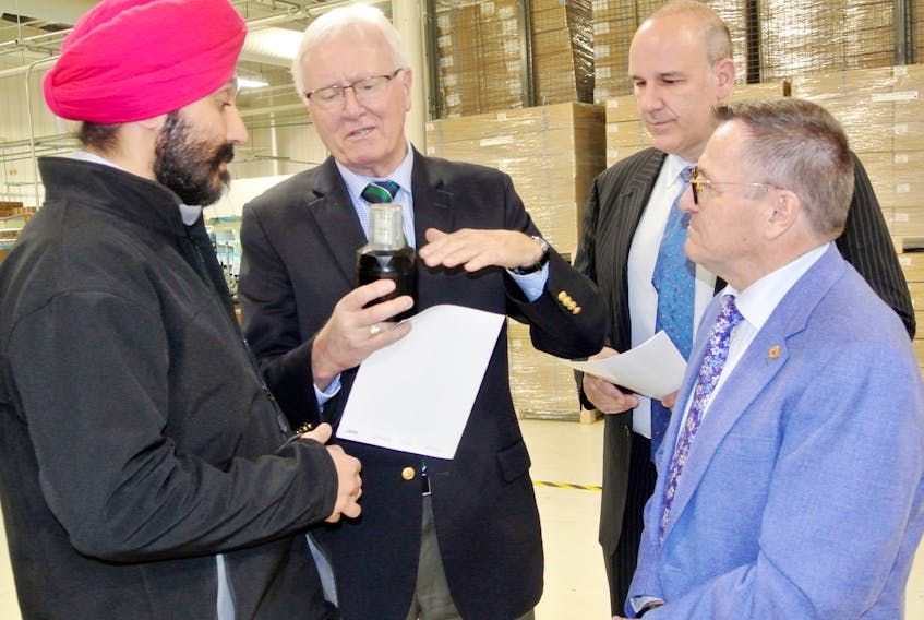 Cumberland-Colchester MP Bill Casey discusses a piece of technology from LED Roadway Lighting with federal Innovation, Science Economic Development Minister Navdeep Bains, provincial Labour and Advanced Education Minister Labi Kousoulis and LED Roadway Lighting CEO Chuck Cartmill after a funding announcement in Amherst on Thursday.