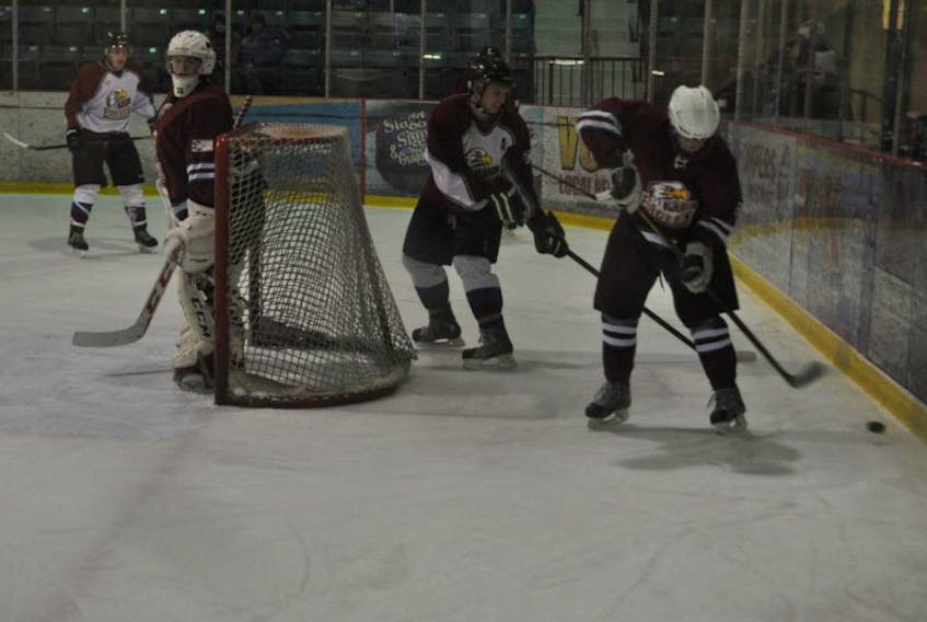 Cody Drover (in white) guards the escape from behind the net in Exploit ’ s Valley  High and Alumni charity game action over the holidays at the Joe Byrne Memo rial  Stadium. Drover now skates with the University of Ottawa and is looking forw ard to  his team ’ s push to make the playoffs on the Ontario university hockey circuit.