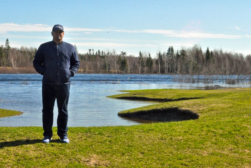 Grand Falls Golf Club president Doug Evans stands by a bunker on the golf course which was still underwater near the 18th hole after flooding on Monday, April 30.