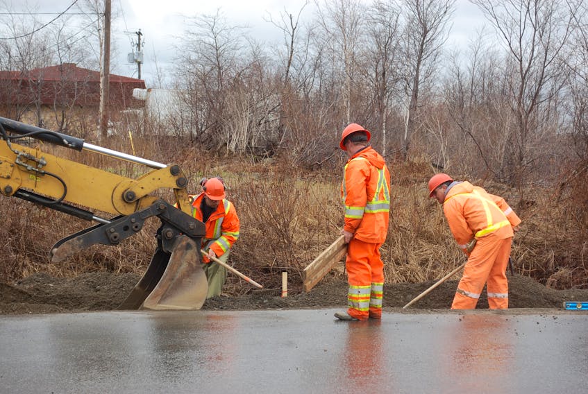 Labourers conduct curb and gutter work near the intersection of Hardy Avenue and Toulett Drive on May 7.