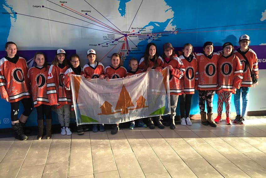 Under 12 Cataracts team members showing off the Town of Grand Falls-Windsor’s flag in the Ottawa international airport.