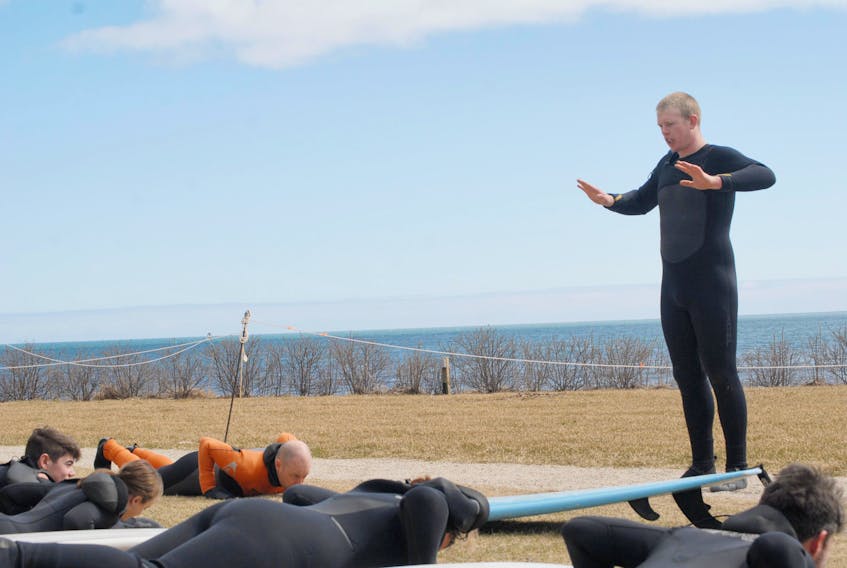 Keith Marble, an instructor with the East Coast Surf School in Lawrencetown, demonstrates techniques during a surfing lesson at White Point Beach Resort March 12.