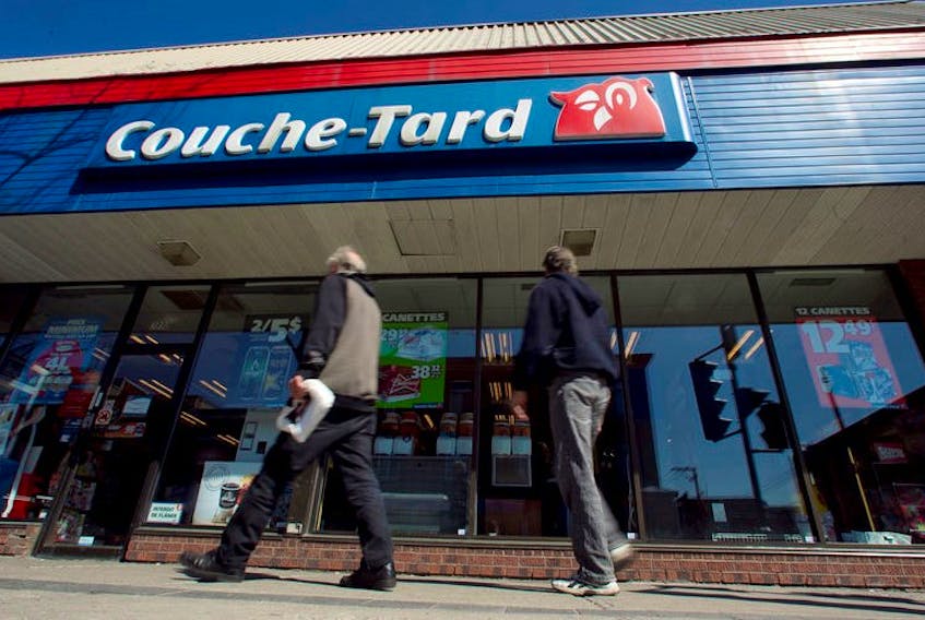 Pedestrians walk past a Couche-Tard convenience store in Montreal. REUTERS/Christinne Muschi