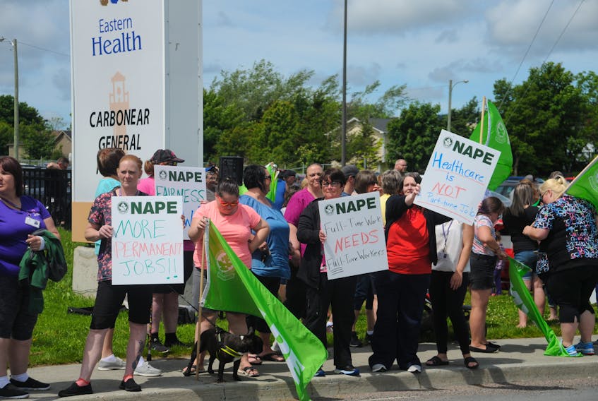Protesters display signs to motorists passing by Carbonear General Hospital Wednesday, July 17. NAPE is raising concerns on behalf of workers at the hospital and nearby long-term care facility about staffing issues. ANDREW ROBINSON/THE COMPASS