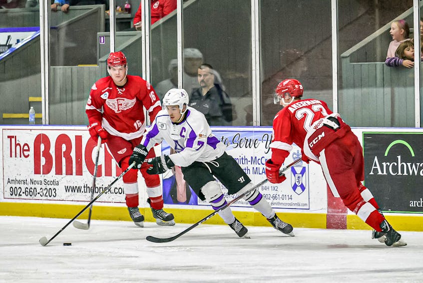 : Amherst Ramblers captain Caleb Rich carries the puck out to centre ice between two Fredericton Red Wings defenders during Maritime Hockey League action at Amherst Stadium.