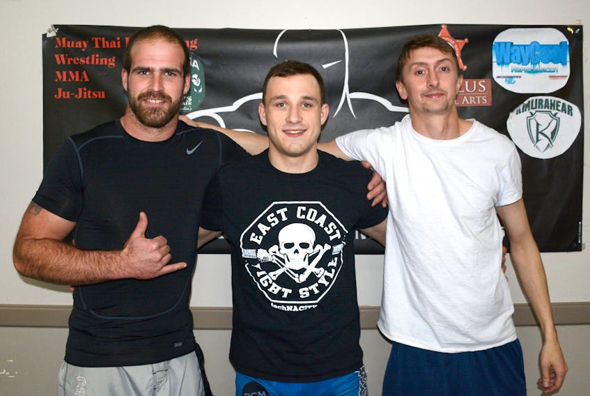 Medal winners (from left) Matthew Fagan, gold, Jerico MacPhee, gold, and Mike Blue, silver, took time out for a quick photo during their jiu-jitsu training session Tuesday night at Cumberland Mixed Martial Arts in Amherst.