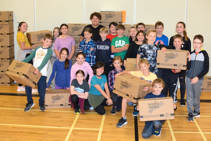 Members of the Cumberland North Academy student council hold up a few of the 200 boxes they recently packed for the Nourish Your Roots program.