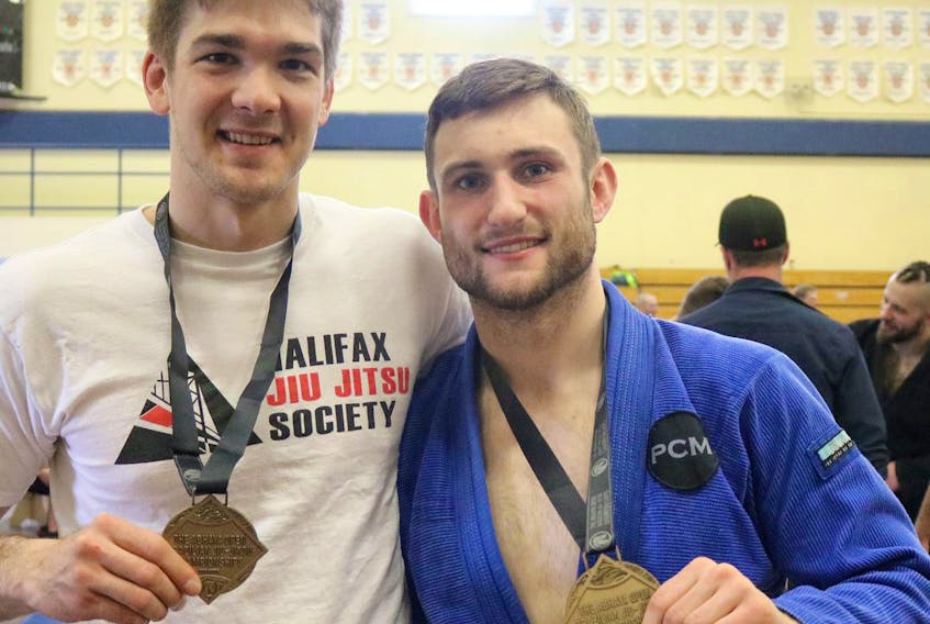 Jeremy Misken (left) and Justus Copeland proudly display the Jiu Jitsu gold medals they earned at the 2018 Abhaya Open Brazilian Jiu Jitsu Championships in Windsor on Saturday. The competition was at King’s-Edgehill School. Misken and Copeland are co-owners of Breakthrough Brazilian Jiu Jitsu in Amherst.