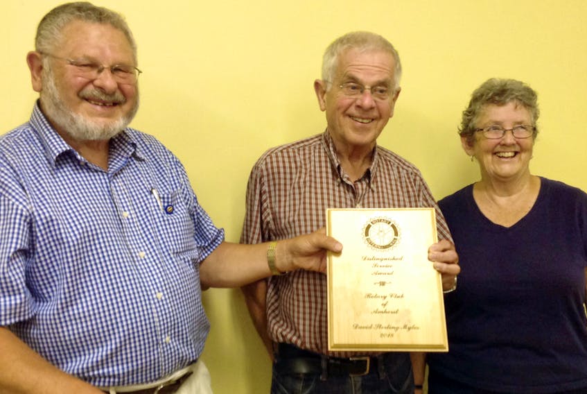 Rotarian Morris Haugg (left) presents the Amherst Rotary Club’s Distinguished Service Award to David Myles while Myles’ wife, Margaret, looks on.