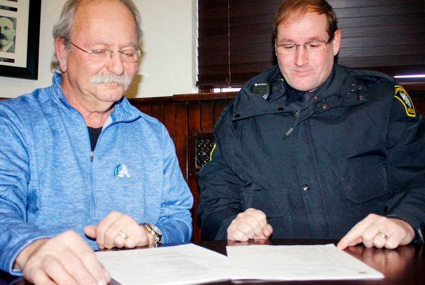 Amherst Mayor David Kogon and Atlantic Police Association Local 104 president Const. Tom Wood look over an arbitrator’s decision that gives Amherst’s unionized police officers a 14.52 per cent raise over five years, when compounding is considered.