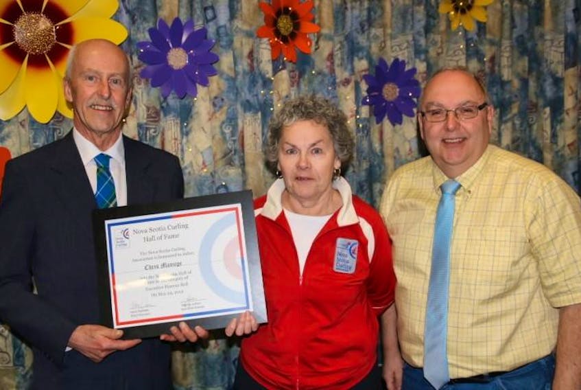 Nova Scotia Curling Association president Harry Daemen (left) presents a Hall of Fame award to Chris Manuge of the Amherst Curling Club while fellow Amherst curler Kim DeLong looks on.