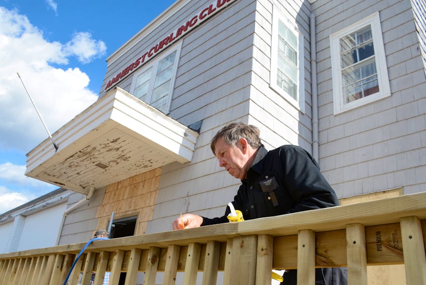Ron Curry was putting some finishing touches onto the new access ramp in front of the Amherst Curling Club Wednesday afternoon. The club was built in the mid-1940s, and Peter Rushton, a volunteer helping with renovations, says the building has a very thick, solid foundation.
