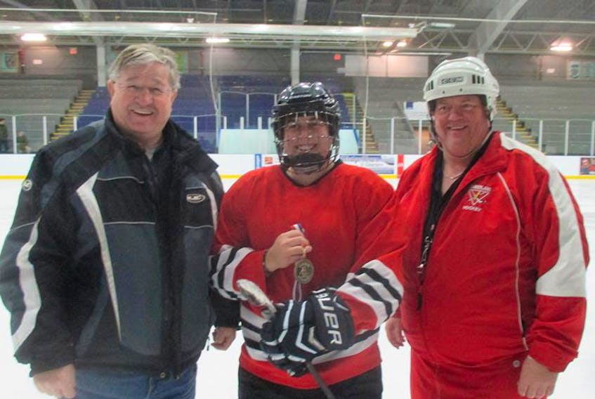 Cross-Border Women’s Recreational Hockey League vice-president Vince Byrne (left) and league president Wayne ‘Butchie’ MacKenzie congratulate Carole Gautreau as the fastest skater in the league’s recent skills competition at the Amherst Stadium.