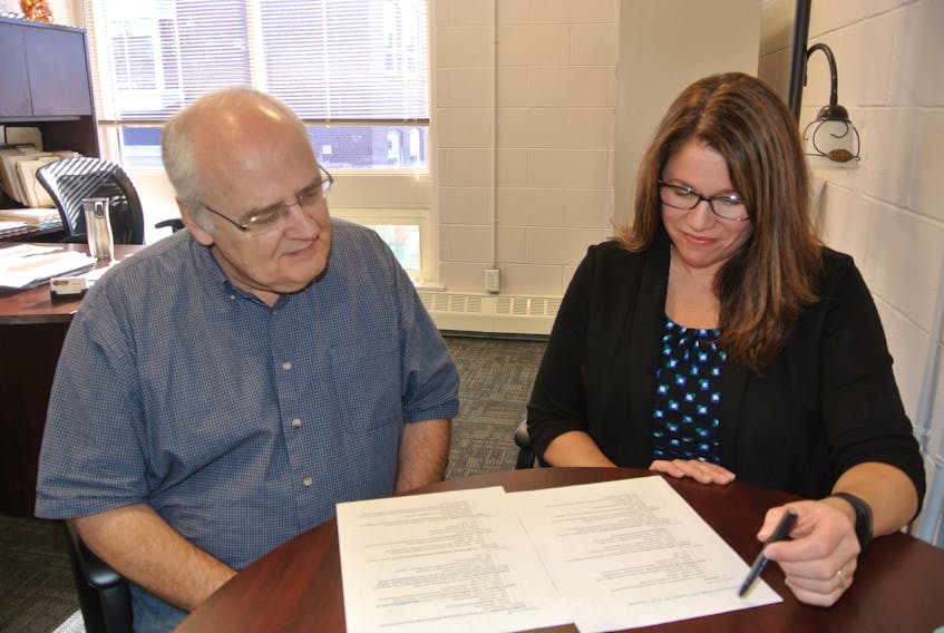 Ron Furlong, executive secretary of the Amherst and Area Chamber of Commerce, and CBDC Cumberland executive director Carys Wood look over plans for Small Business Week in Cumberland County.