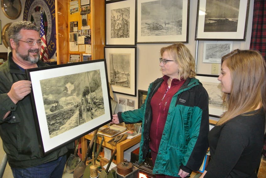 John Wales from the North Nova Scotia Highlanders Regimental Museum discusses an Arthur Lismer lithograph with Amherst Area Heritage Trust members Dale Davis and Jennifer Cameron. Amherst Area Heritage Trust will be showcasing the museum’s lithographs during An Evening of Art and War: Arthur Lismer Comes to Town, on Friday, Nov. 16 at 8 p.m. at the Col. James Layton Ralston Armoury.