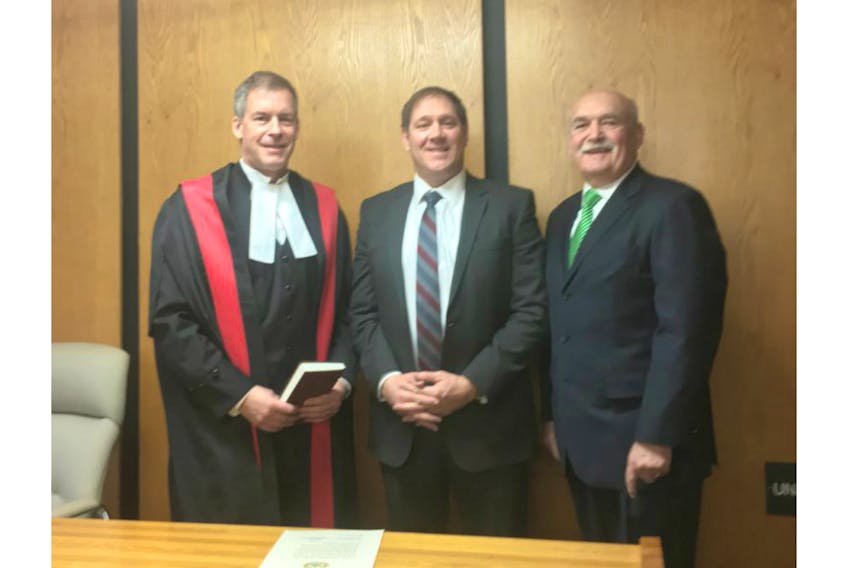 The Atlantic Police Academy’s newly appointed executive director, Forrest Spencer, is sworn in by Judge Jeffrey E. Lantz, left, in the courthouse in Summerside while Holland College president Brian McMillan looks on.