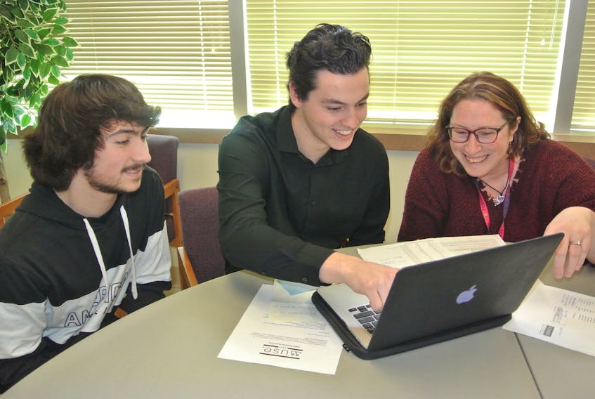 (From left) ARHS student Jacob Legere, NSCC business student Brendan Stone and ARHS languages and fine arts department head Lesley Parliament-Taylor look over plans for the first MUSE Awards at Amherst Regional High School on June 10.