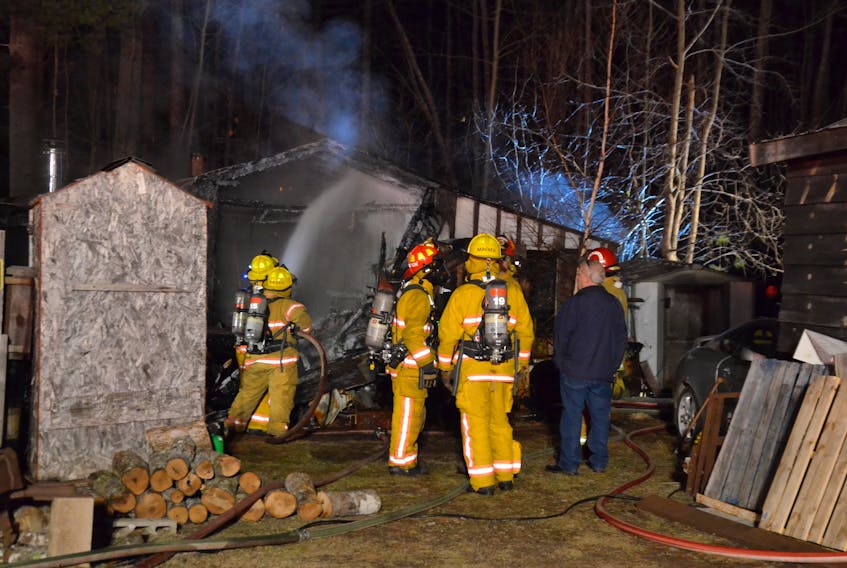 Firefighters hose down the interior of a garage in Wilmot that caught fire at about 8:30 p.m. on Feb. 27. While much of the garage and contents were destroyed, firefighters kept the flames from spreading to nearby homes.