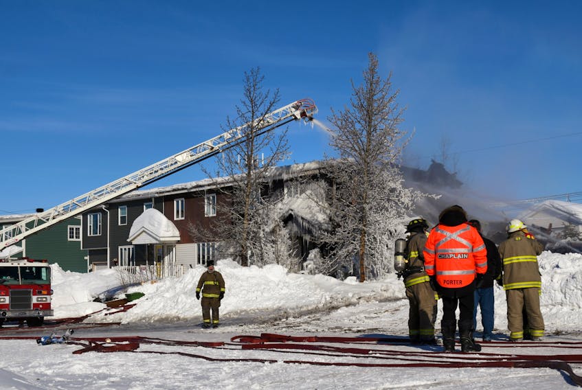 Firefighters chaplain Lt. Norm Porter talks with firefighters to see what assistance he can give at the scene of a house fire in Wabush on Feb. 14.