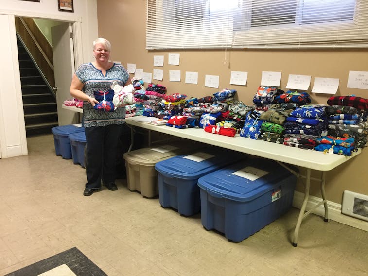 Melinda Myers with new pyjamas donated to her annual drive. The boxes under the table are also filled with sleepwear.