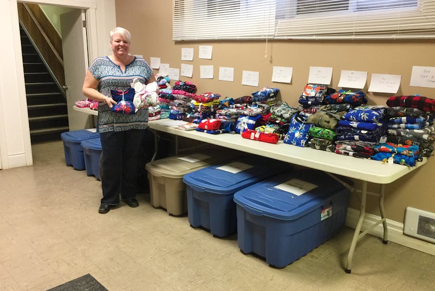 Melinda Myers with new pyjamas donated to her annual drive. The boxes under the table are also filled with sleepwear.