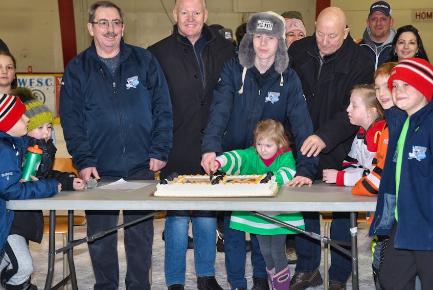 Labrador West minor hockey players Brayden King and Zanita Fancy help cut the cake to mark the start of Minor Hockey Week.