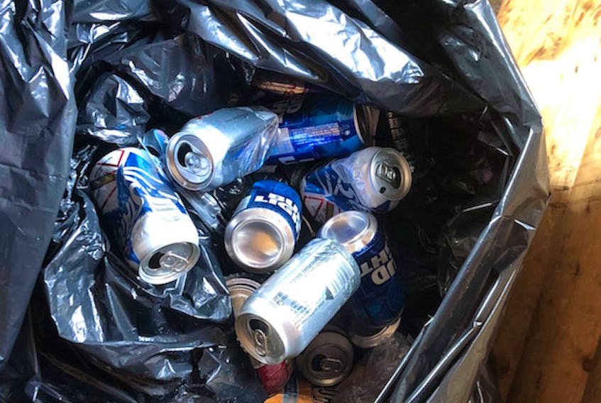 A garbage can full of empty beer cans at the White Wolf Snowmobile Club facility.
